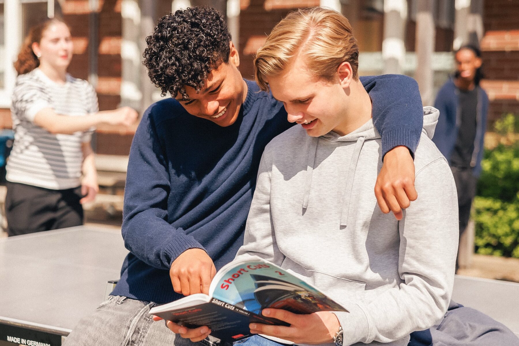 Gymnasiestudenter som kramar om varandra