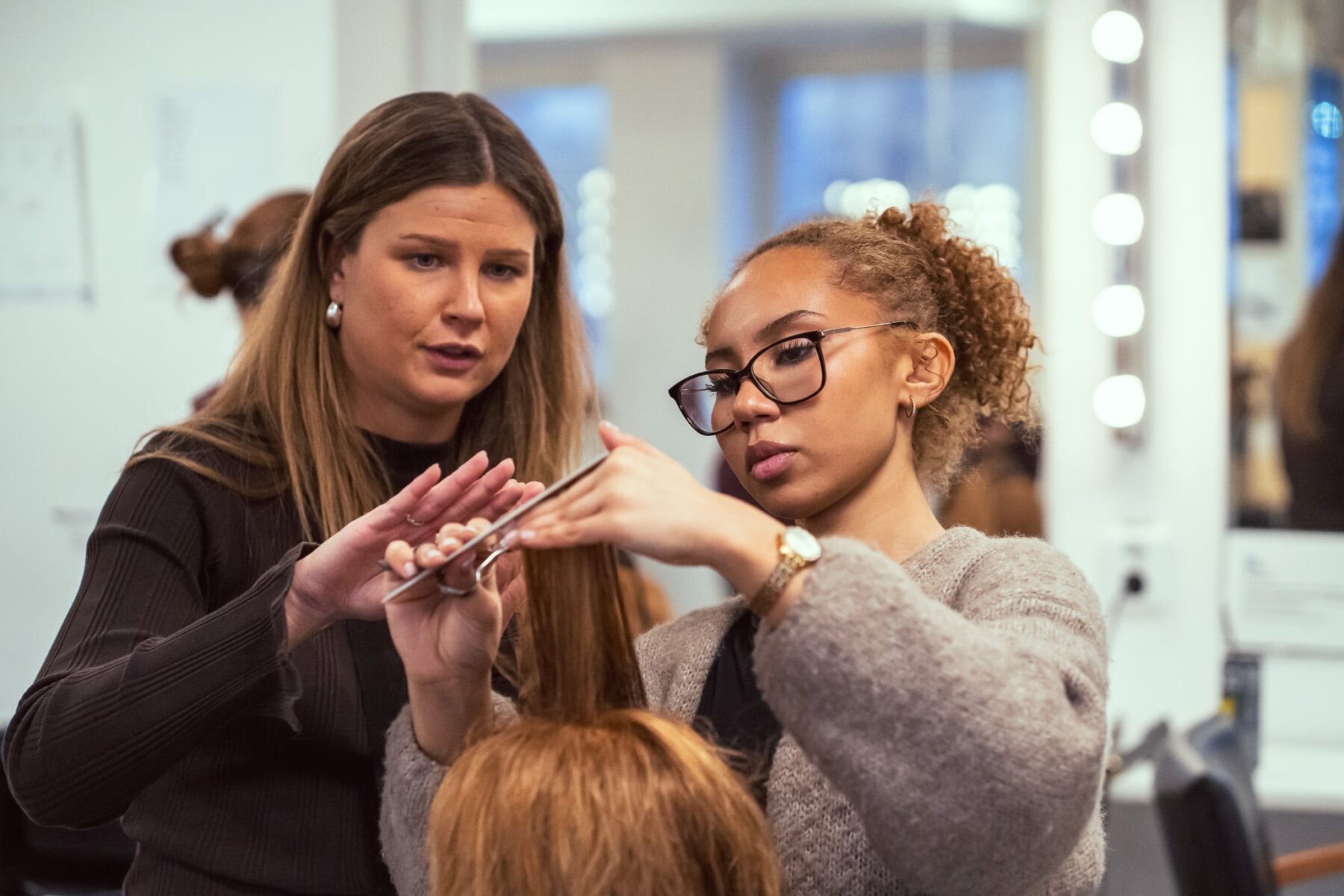 En lärare och student på Grillska Gymnasiets yrkesprogram inom frisör