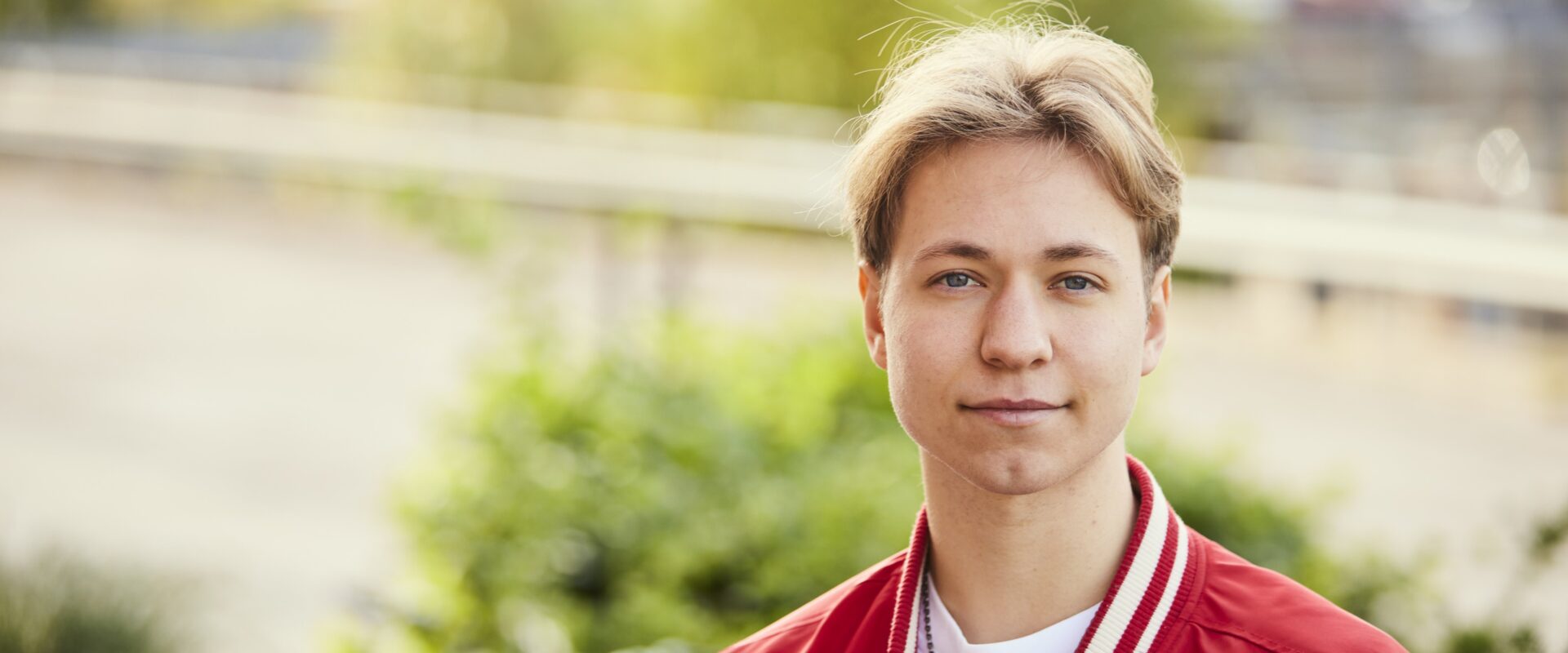 Elev på Samhällsvetenskapsprogrammet Samhälle med socialt engagemang står utomhus och ser in i kameran.