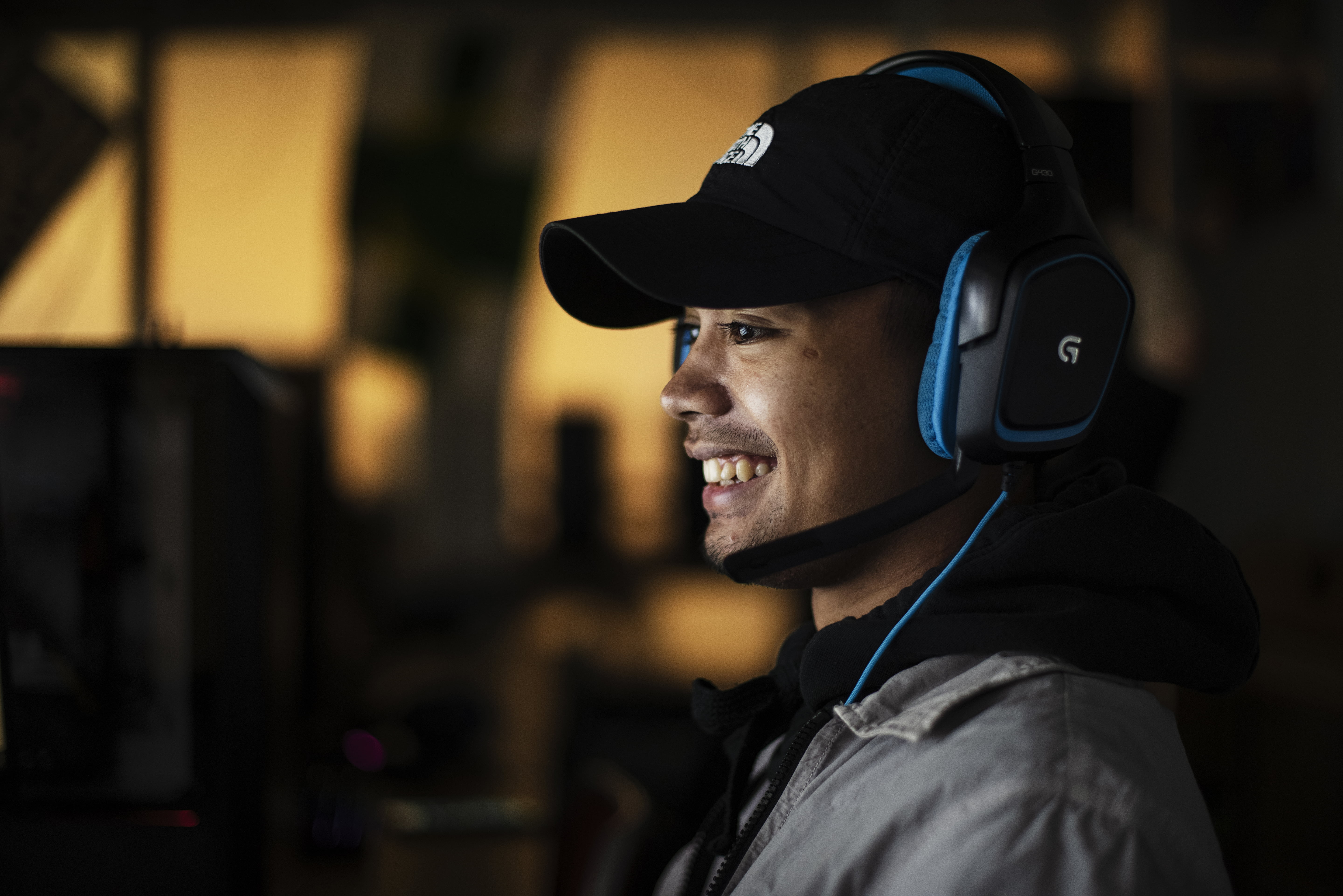 Elev med headset spelar esport vid en dator i en mörk miljö.