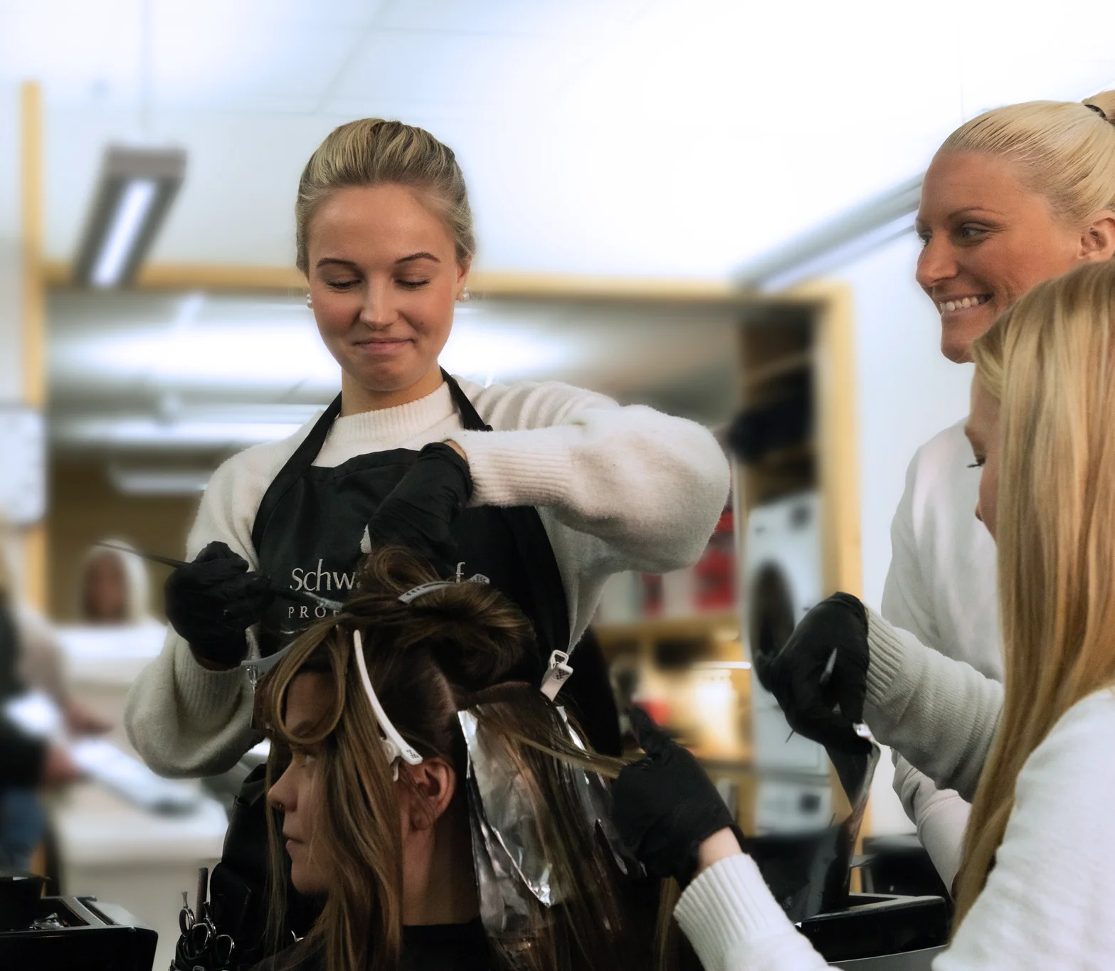 Mathilda och Elin färgar håret på en tjej.