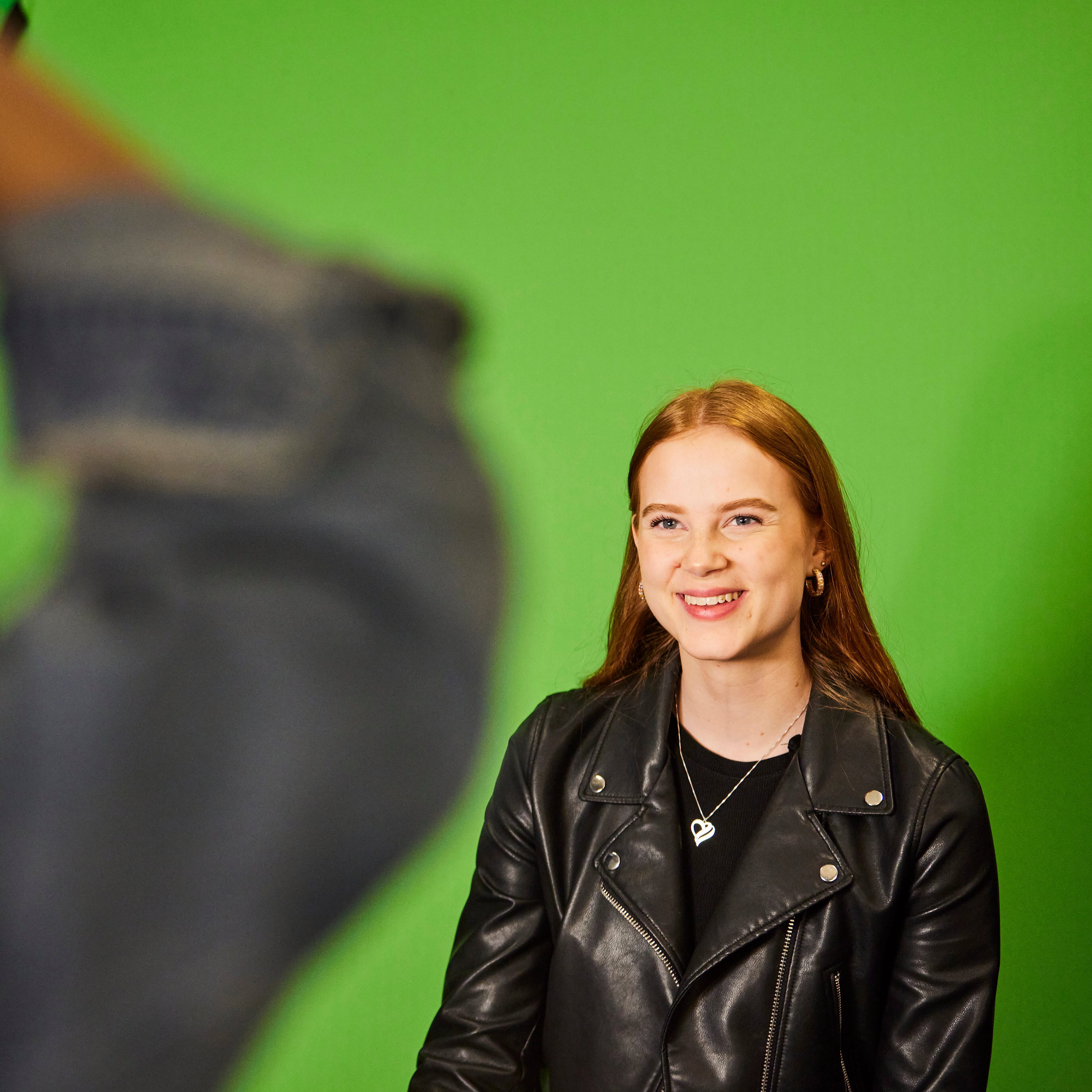 Elev blir fotad framför en greenscreen.