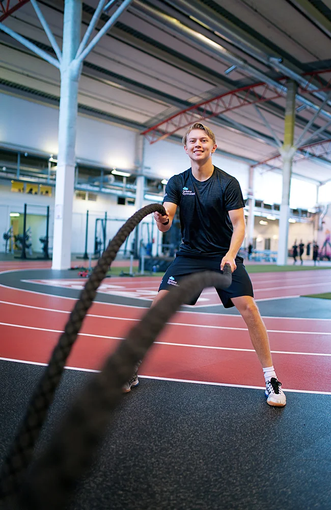 Elev tränar med rep på inomhusbana, iförd träningskläder från Grillska Gymnasiet.