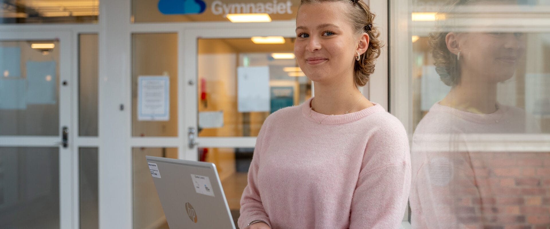 En ung elev på Gymnasiet. Hon håller i en dator.