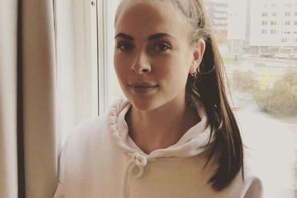 Porträtt av eleven Anne-Mo i vit hoodie, tittar åt sidan inomhus.