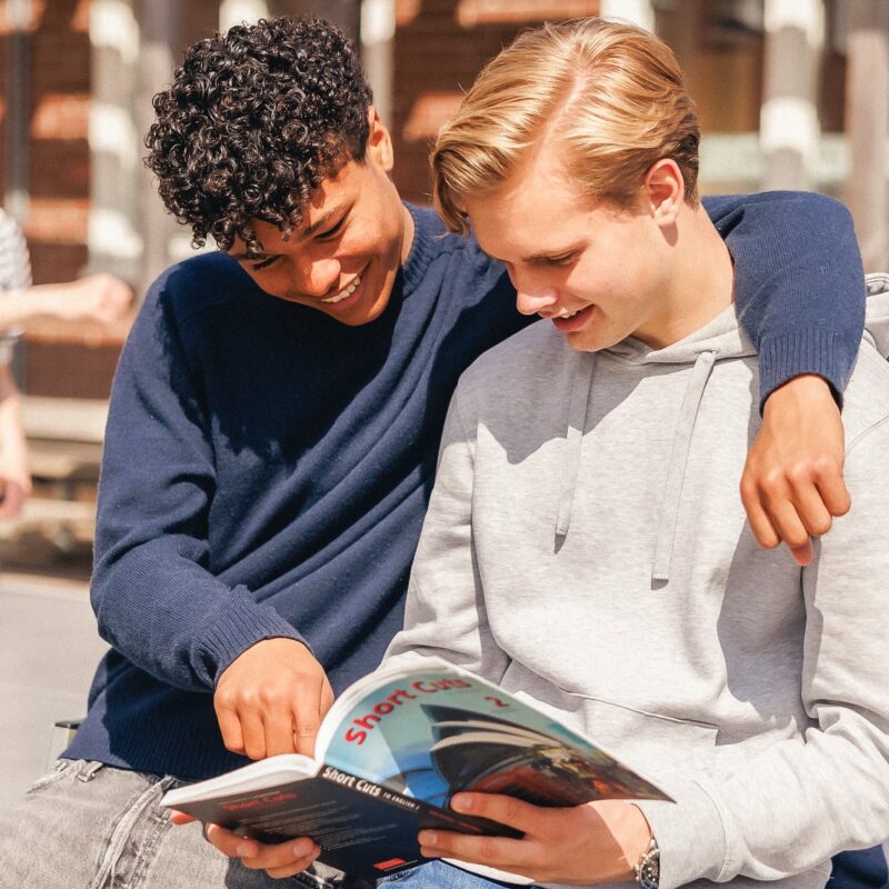 Två gymnasieelever på en skolgård